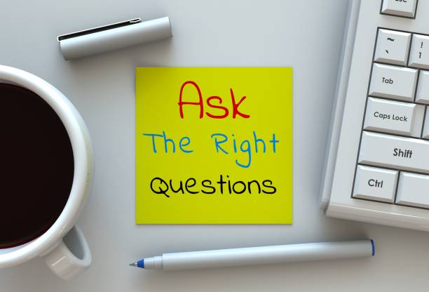 Ask The Right Questions, message on note paper, computer and coffee on table stock photo
