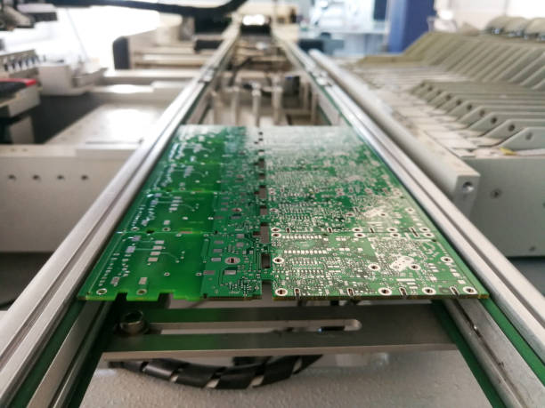 PCB assembly first stages. PCB on the rails of production line inside pick and place machine stock photo