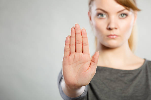 Assertive woman making stop gesture. Communication psychology negative defensive concept. Assertive woman making stop gesture. Strong blonde lady showing hold sign. assertiveness stock pictures, royalty-free photos & images