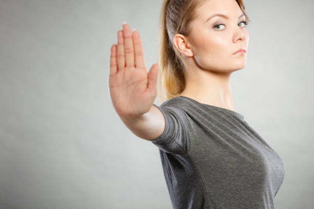 Assertive woman making stop gesture. Communication psychology negative defensive concept. Assertive woman making stop gesture. Strong blonde lady showing hold sign. assertiveness stock pictures, royalty-free photos & images
