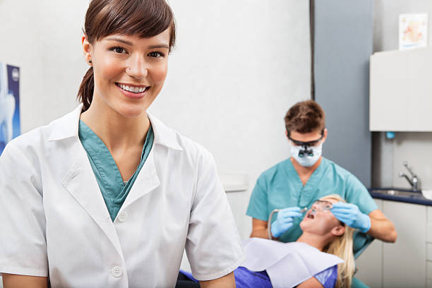 Assistant with dentistry work in the background stock photo