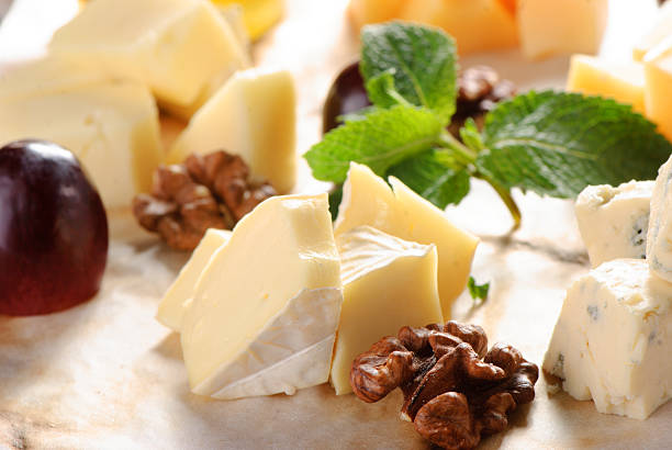 Assorted cheese on a wooden board stock photo