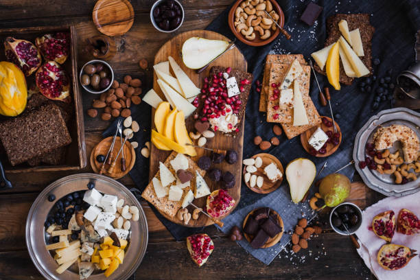 Assorted cheeses fruits nuts platter Gourmet party delicatessen table food salumeria buffet appetizer stock pictures, royalty-free photos & images