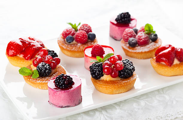 Assorted desserts Assorted  fruit tartlets and pieces of cakes for holiday tart dessert photos stock pictures, royalty-free photos & images