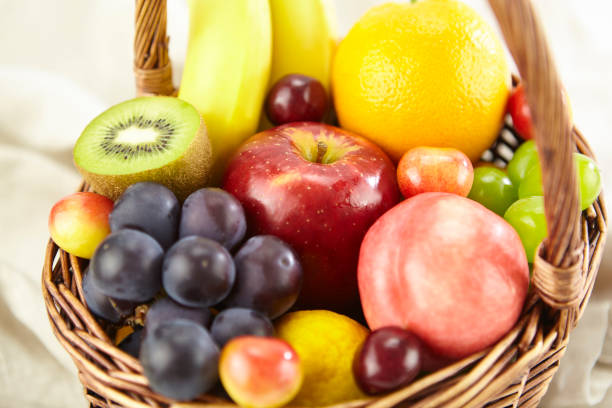 assorted fresh fruits in a basket stock photo