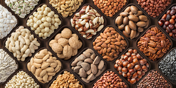 seeds and nuts background, natural food in wooden bowls, top view.
