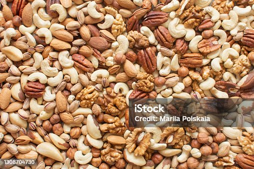 istock Assorted nuts: hazelnuts, walnuts, brazilian nuts, pecans, pistachio, almonds, cashews Flatlay organic mixed nuts background. Healthy food, useful microelements and vitamins. Useful health snack. 1308704730