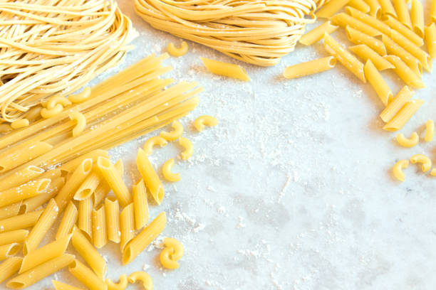 Assorted Raw Pasta Assorted italian Raw Uncooked Pasta on white background with copy space for text uncooked pasta stock pictures, royalty-free photos & images