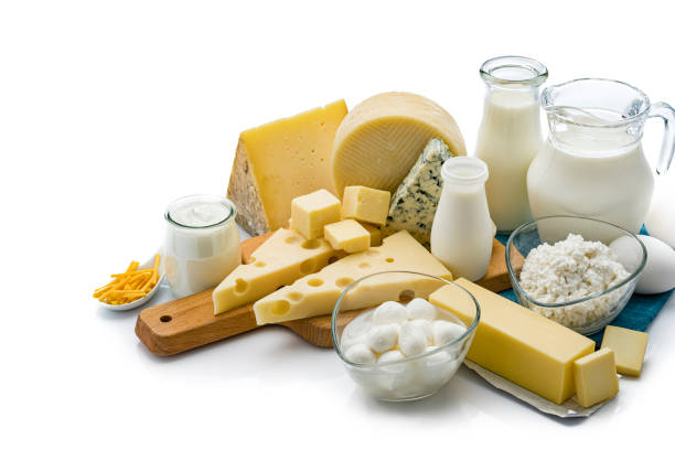 Assortment of dairy products isolated on white background Large assortment of most common dairy products shot on white background. The composition includes milk, sour cream, butter, yogurt, eggs, Manchego cheese, goat cheese, emmental cheese, Cheddar cheese, Roquefort cheese and cottage cheese. Some cheeses are on a wooden cutting board and the milk bottle, eggs and the cottage cheese are sitting on a blue folded tablecloth. Predominant colors are white, yellow and blue. High resolution 42Mp studio digital capture taken with SONY A7rII and Zeiss Batis 40mm F2.0 CF dairy product stock pictures, royalty-free photos & images