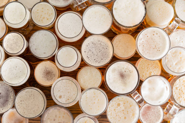 Assortment of full, frothy beer glasses and sizes stock photo