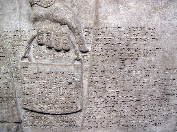 Assyrian Cuniform Script 865-860 BC Assyrian relief 865-860 BC, showing cuniform script, and a royal helper carrying a bucket mesopotamian stock pictures, royalty-free photos & images