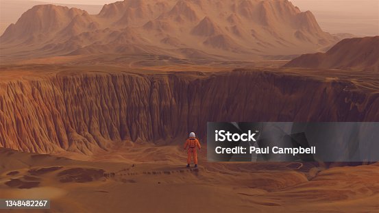 istock Astronaut Explorer Large Crater Arid Mountain Extra-Terrestrial Planet Desert Landscape 1348482267