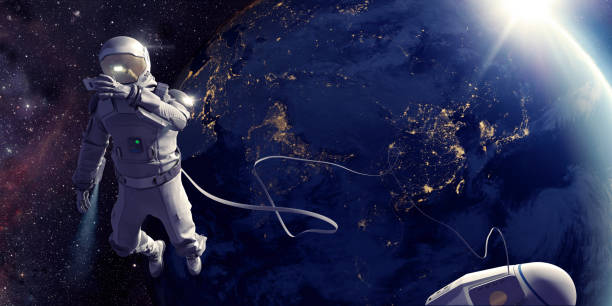 Astronaut On Spacewalk Taking Selfie In Front Of Earth Astronaut connected to a tethered lifeline floats in space, holding up a device to take a selfie with the nighttime city lights of planet earth, as the sun rises. Distant stars and galaxies are visible in the background. Credit: NASA https://earthobservatory.nasa.gov/images/79790/city-lights-of-asia-and-australia and ESO for background images. astronaut stock pictures, royalty-free photos & images
