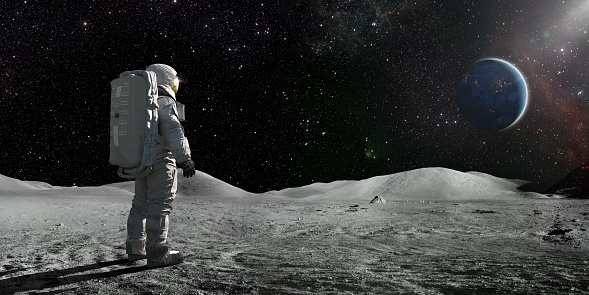 Astronauta de pie en la Luna mirando hacia una Tierra distante photo