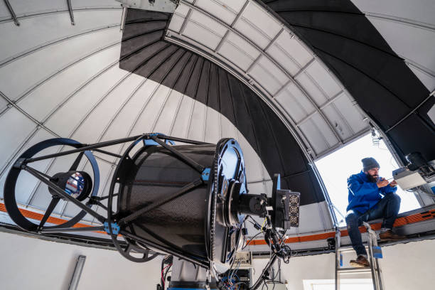 Astronomer technician in observatory dome Astronomer technician in observatory telescope dome doing shutter maintenance tasks observatory stock pictures, royalty-free photos & images