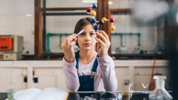 At a chemistry class Schoolgirl in a chemical laboratory at a class of chemistry one girl only stock pictures, royalty-free photos & images