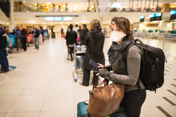 At the airport with a face mask Woman waiting in a long line for a flight wearing a N95 face mask during a global pandemic south africa covid stock pictures, royalty-free photos & images