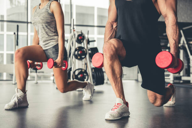 At the gym Attractive sports people are working out with dumbbells in gym body building stock pictures, royalty-free photos & images