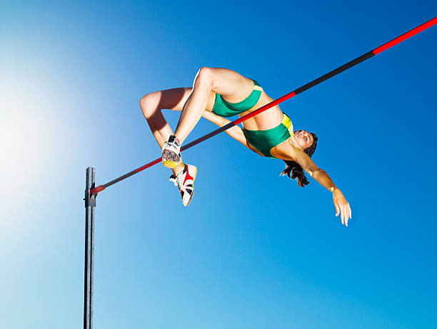 sportler high-jumping in der arena - leichtathlet stock-fotos und bilder