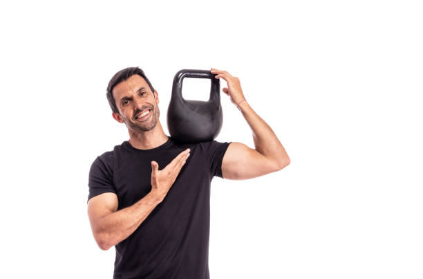 Athlete is a European man, holding a weight on shoulder, pointing with finger, advertising a healthy sports lifestyle. On a white background. stock photo