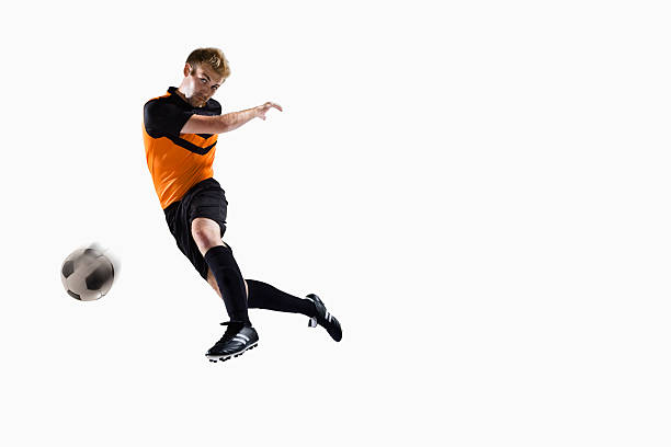 Athlete kicking soccer ball stock photo