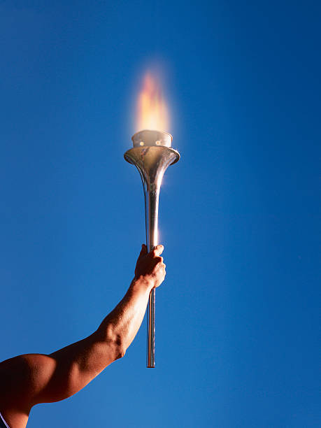 athlete's arm holding up a torch - alleen jonge mannen stockfoto's en -beelden
