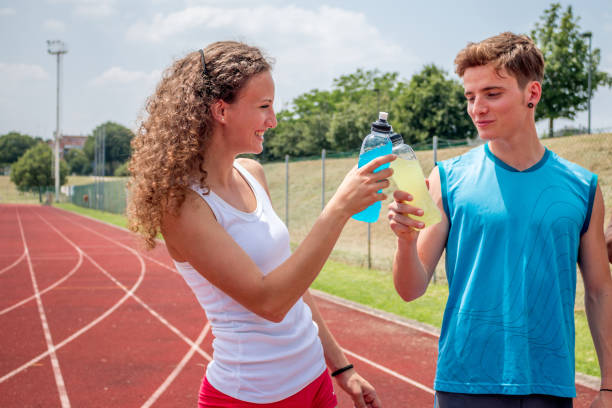 athletes taking a break with energy drink stock photo