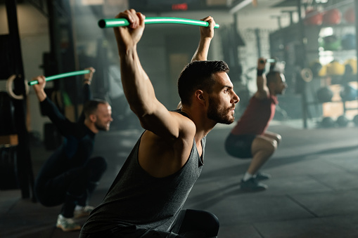 Athletic Men Exercising With Rods On Cross Training In A Gym Stock Photo -  Download Image Now - iStock