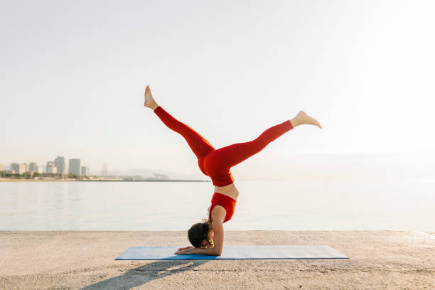 Athletic young hispanic woman in red sportswear doing yoga in the morning stock photo