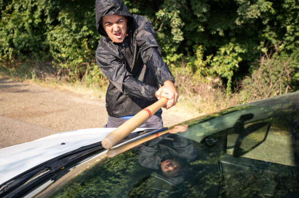 Attacker trying to break a windshield with a baseball bat Attacker trying to break a windshield with a baseball bat vandalism stock pictures, royalty-free photos & images