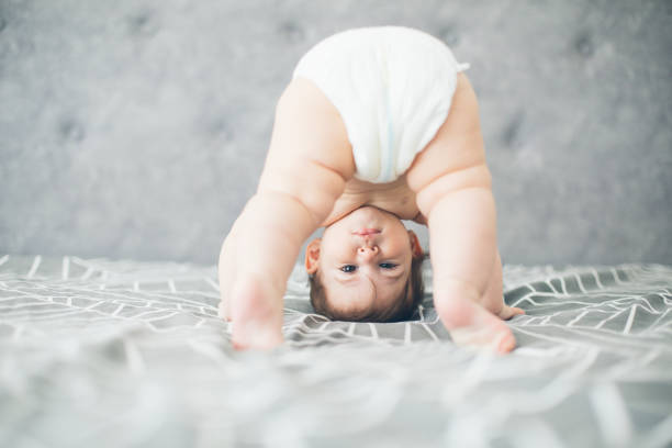 Attempting my first steps Baby standing upside down on a bed, attempting to stand or crawl crawling stock pictures, royalty-free photos & images