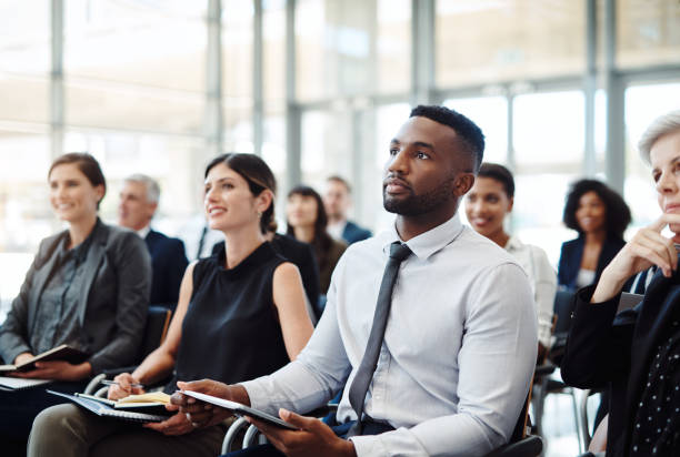 Attending a conference to develop their careers Shot of a group of businesspeople attending a conference development stock pictures, royalty-free photos & images