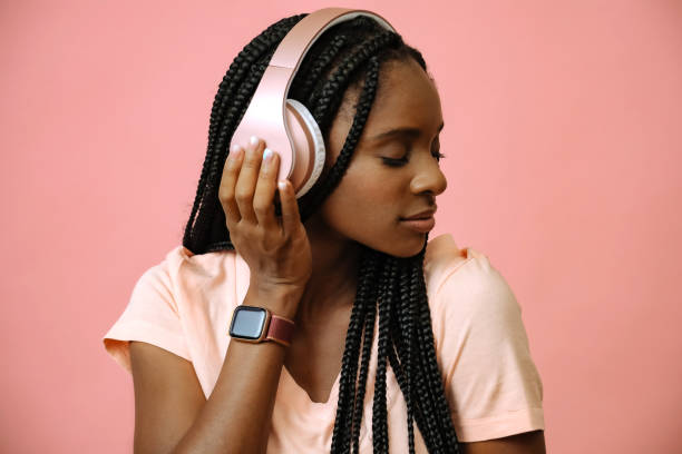 attractive african woman listening music in headphones stock photo