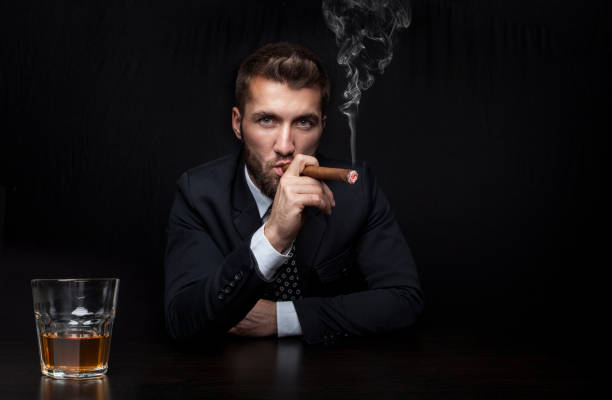Attractive business man with a cigar and a drink stock photo