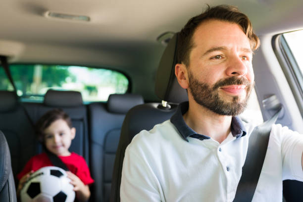 Attractive dad taking his cute kid to class On our way to soccer practice. Handsome hispanic man in his 30s driving his adorable young son to football classes in the afternoon mexico soccer stock pictures, royalty-free photos & images