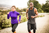 Image of an attractive African American man and Hispanic woman running for exercise