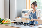 キッチンで調理魅力的な日本人女性