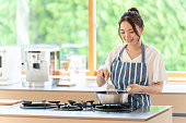 キッチンで調理魅力的な日本人女性