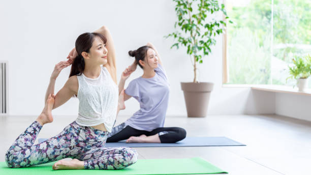 リビングルームで運動する魅力的な日本の女性 - yoga ストックフォトと画像