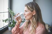istock attractive middle aged woman in the office ( drinking water) 1317466829