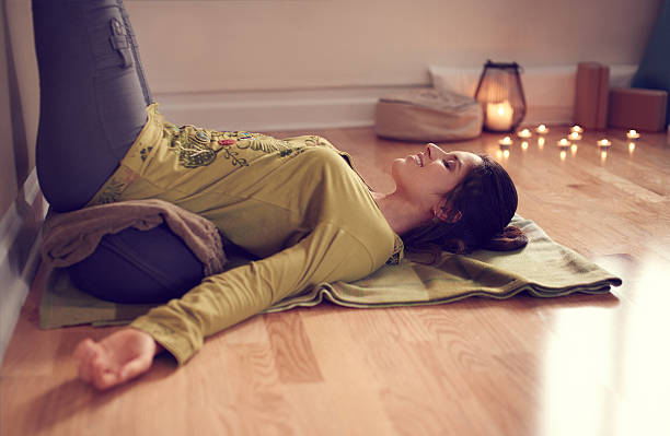 Attractive mixed race woman doing restorative yoga stock photo