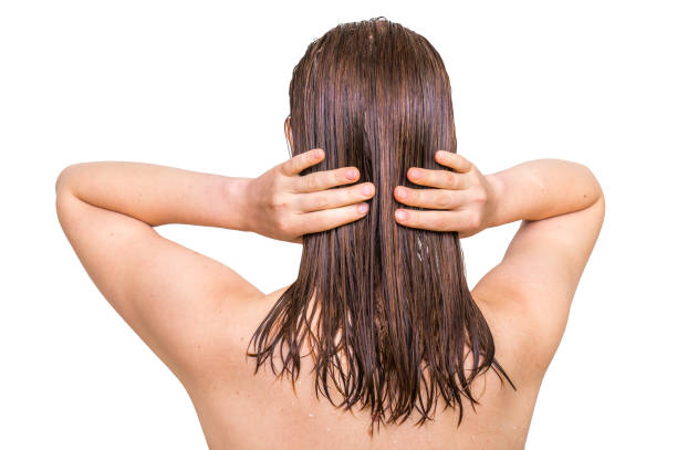 aantrekkelijke vrouw conditioner toe te passen op haar haren - woman washing hair stockfoto's en -beelden