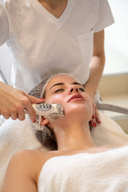 Attractive woman getting skin rejuvenation with RF lifting apparatus at professional beauty salon stock photo