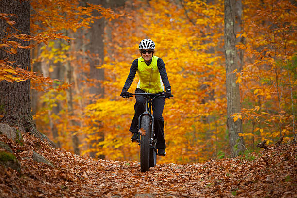 Attractive woman riding a fatbike in the fall stock photo