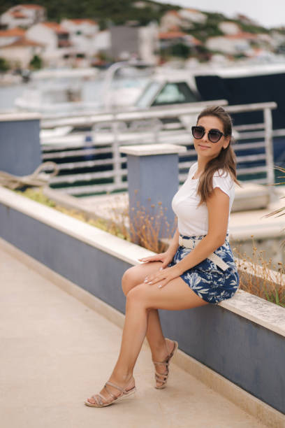 aantrekkelijke vrouw staan op de pier. achtergrond van boten - fluisterboot stockfoto's en -beelden