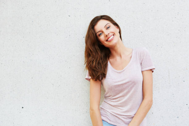 attraktive junge dame lächelnd vor weißem hintergrund - frauen über 30 stock-fotos und bilder