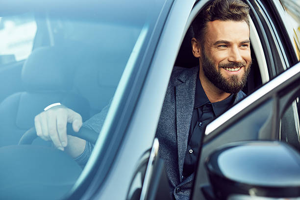 attractive young man sitting in car - man with car stockfoto's en -beelden
