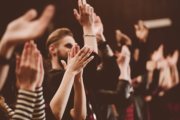 Audience applauding in the theater Group of people clapping hands in the theater, close up of hands. Dark tone. applauding stock pictures, royalty-free photos & images