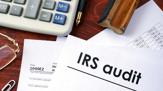 IRS audit title on a document and 1040 form.