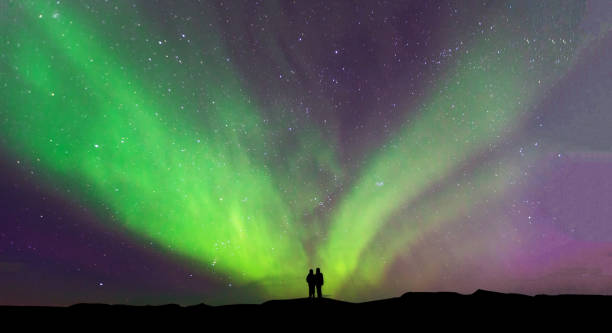 Aurora borealis with silhouette standing photographer on the mountain.Freedom traveller journey concept stock photo